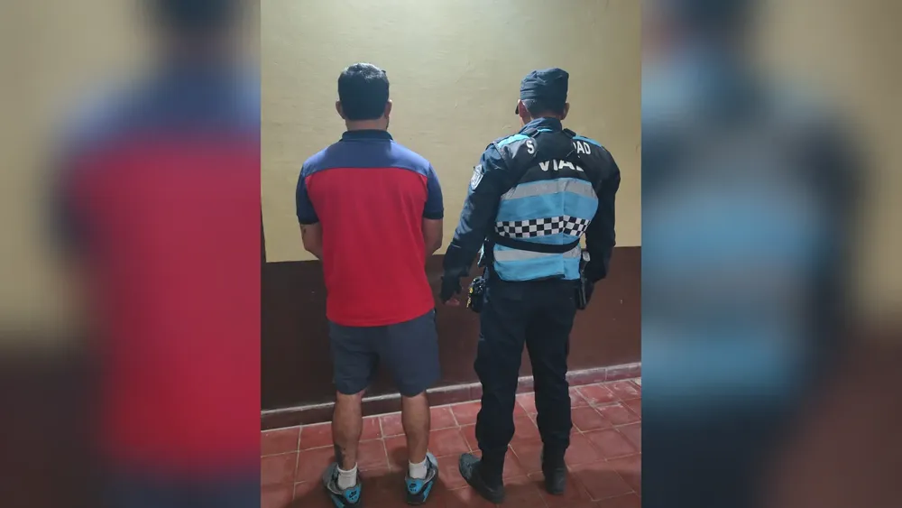 Detenido y policía vistos de espaldas